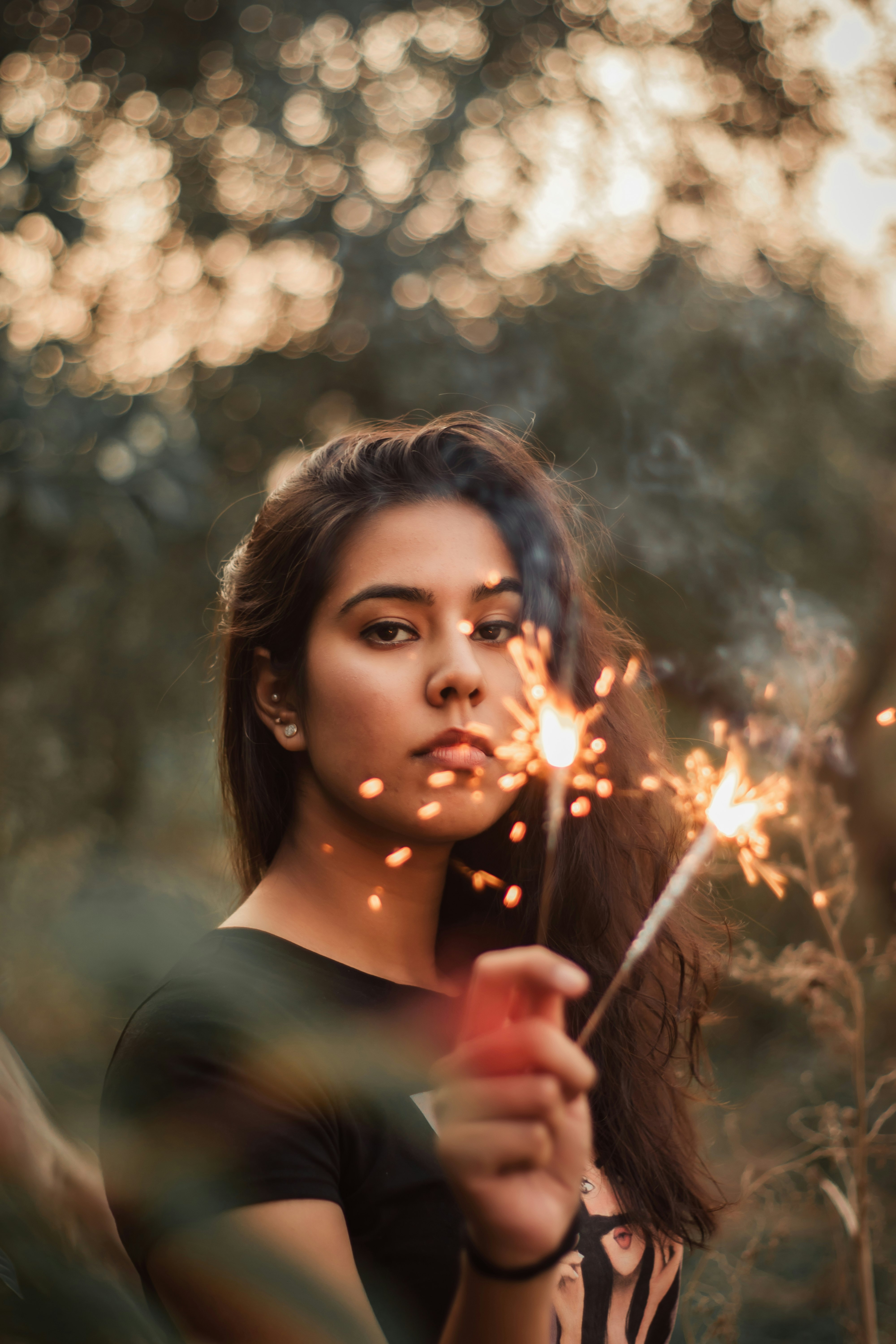 woman in black long sleeve shirt holding sparkler